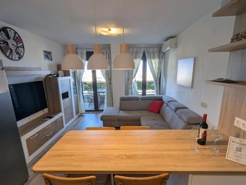 Dining table in the living room with the sofa and terrace doors behind
