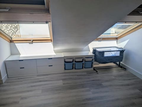 Space under the skylights with a travel cot and storage