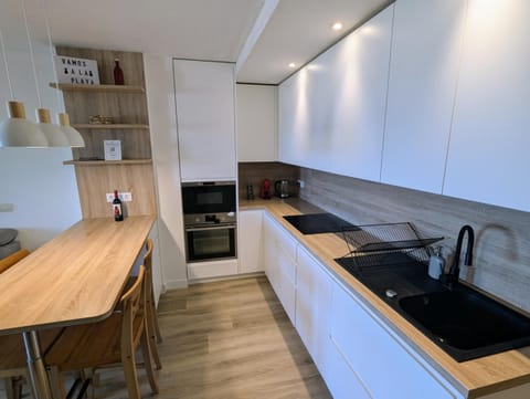 Kitchen with wooden breakfast bar, oven and microwave