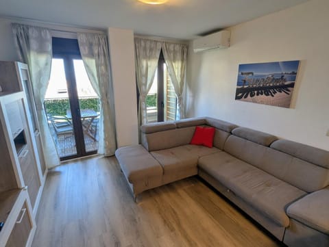 Living room with corner sofa and doors to the sunny terrace