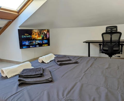 Upstairs bedroom with wall-mounted smart TV and work desk