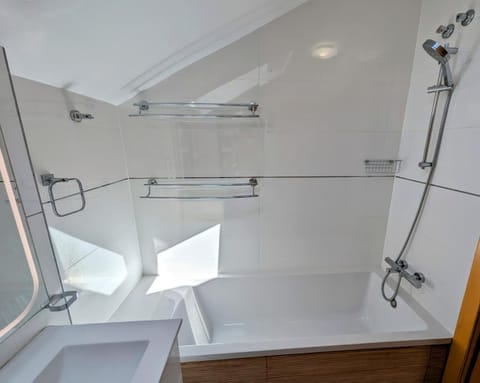 Bathtub with shower and glass screen in the upstairs bathroom